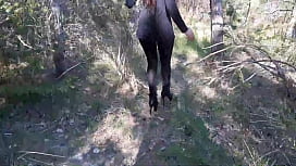 Walking on the wood wearing a black dress pantyhose and high heels ankle boots